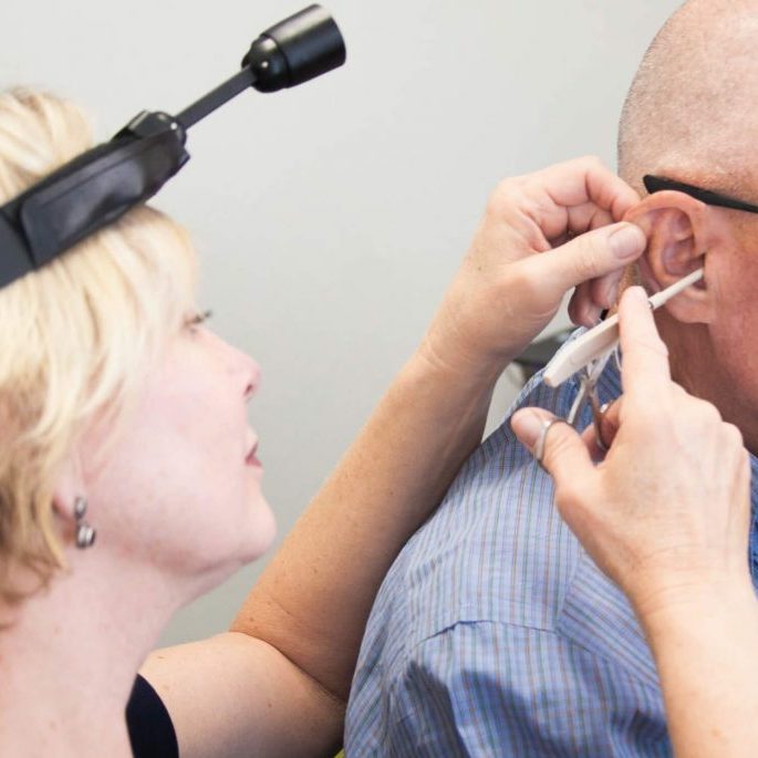 Audiologist taking a mold of a patient's ear