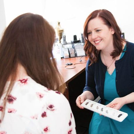 Audiologist showing the latest models of hearing aids to a patient.